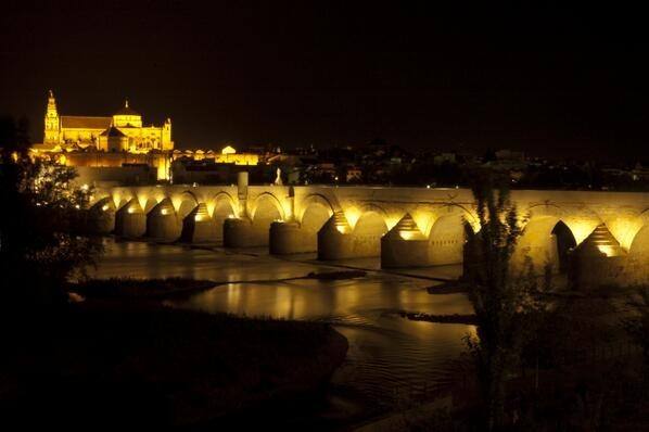 Córdoba iluminada de noche sobre el río Guadalquivir