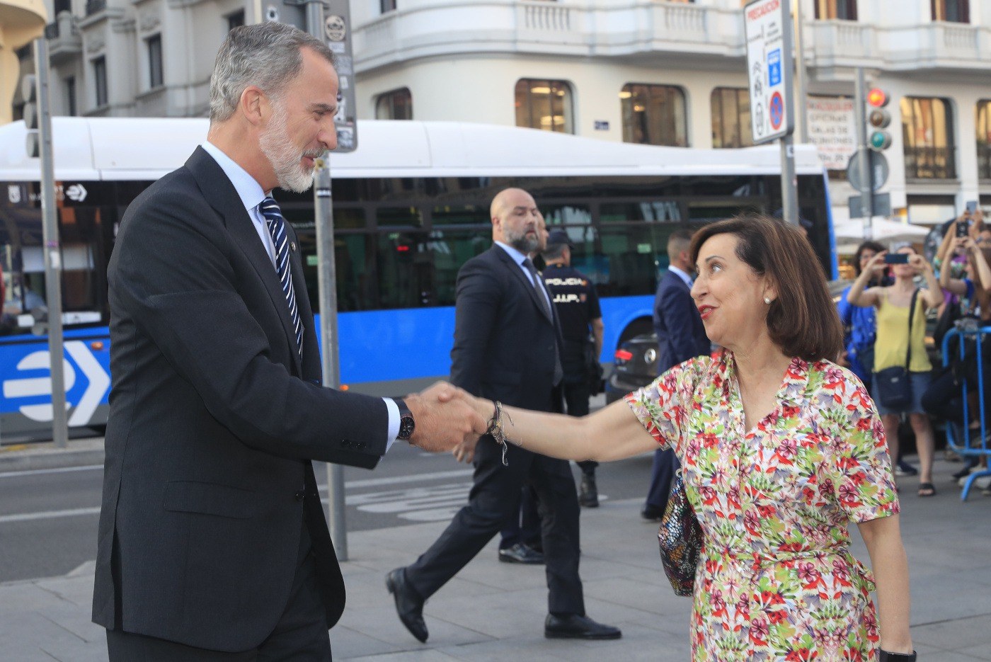 Su Majestad el Rey recibe el saludo de la ministra de Defensa, Margarita Robles, a su llegada al evento