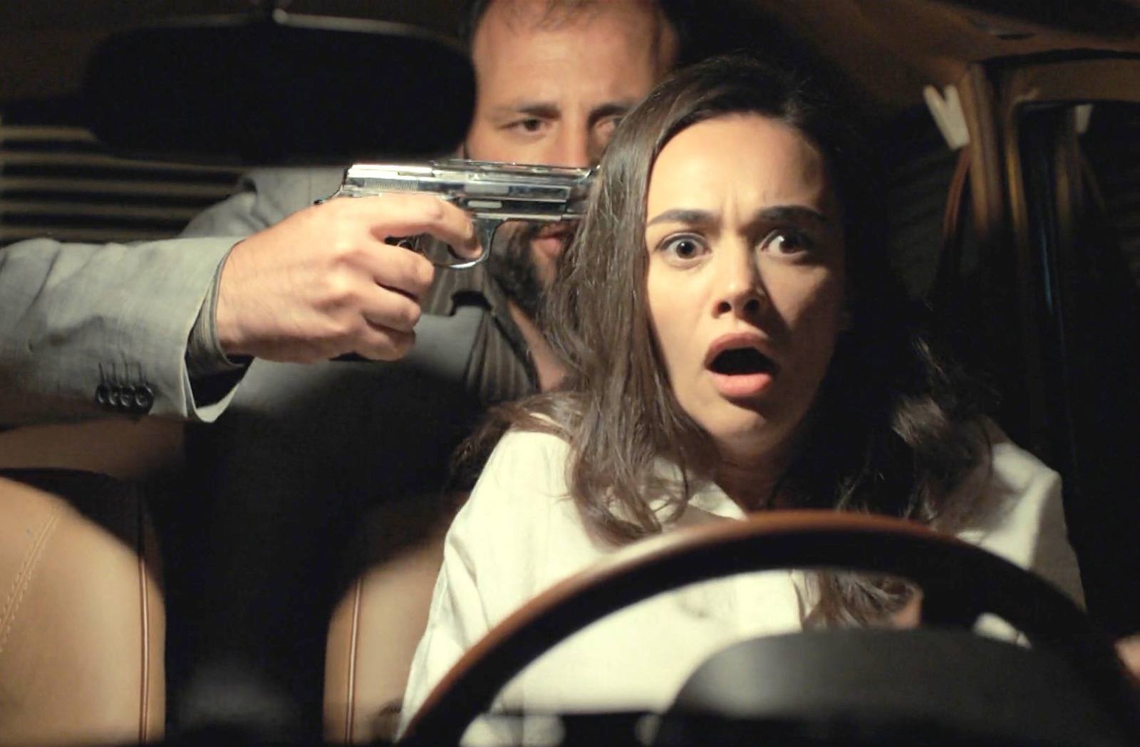 Un hombre escondido en los asientos traseros del coche sorprende a Ümit y la obliga a detenerse a punta de pistola
